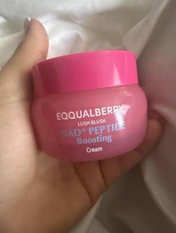 Jar of EQQUALBERRY Lush Blush NAD+ Peptide Boosting Cream held in a hand