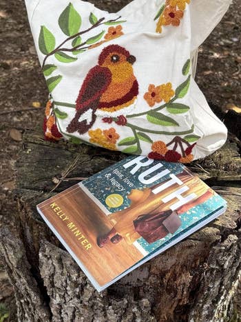 Tote bag with floral embroidery next to a cookbook titled 