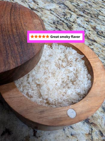 Open wooden salt cellar with coarse salt and a review stating