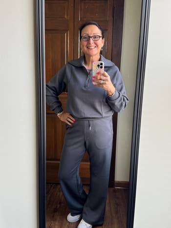 Person in a comfortable, casual tracksuit poses in front of a mirror for a shopping article