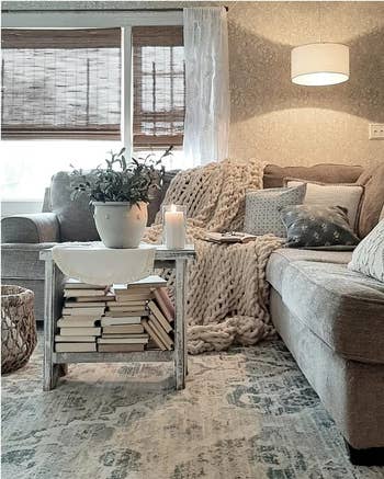 Cozy living room with a grey sofa and knit throw blanket with pillows