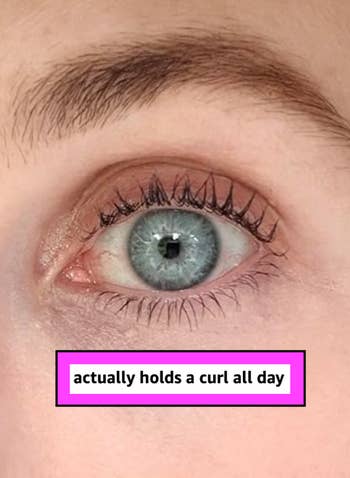 Close-up of an eye with curled lashes, text reads: “actually holds a curl all day.”