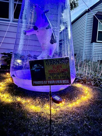 a sign warning of alien abduction in front of the UFO