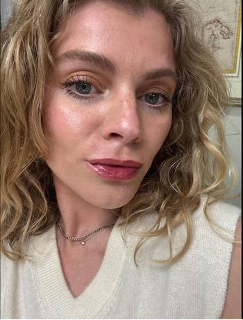 Person with wavy hair wears a sleeveless knit top and a simple necklace, suitable for casual or shopping attire