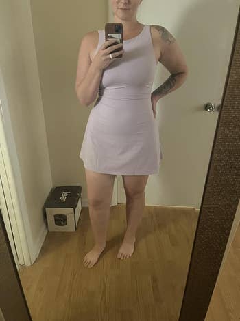 Person in a sleeveless dress takes a mirror selfie, showcasing the outfit's fit and length, suitable for a shopping article focus on casual fashion