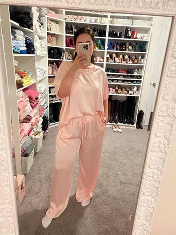 A reviewer taking a mirror selfie wearing silk pajamas