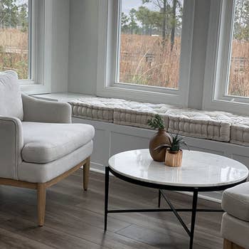 reviewer's living room with several cushions on the lower wooden shelf