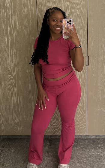 Person taking a mirror selfie in a stylish, form-fitting T-shirt and pants set