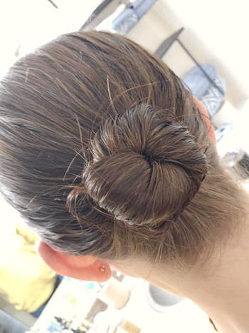 Close-up of a reviewers neatly styled bun on the back of a person's head, showcasing a sleek, elegant hair twist suitable for formal occasions