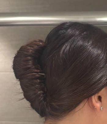 Close-up of a reviewers's sleek, twisted chignon hairstyle, showcasing a smooth, elegant updo suitable for formal events