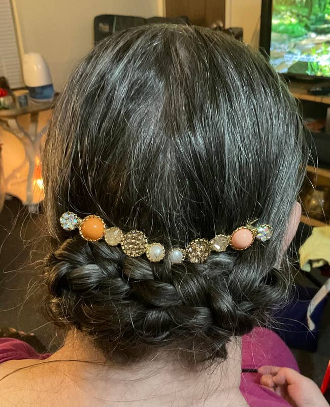Braided hairstyle adorned with a decorative hair clip with pearls and gem-like stones