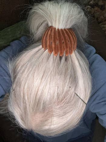 Top-down view of a reviewer with gray hair styled in a bun, secured with a claw hair clip